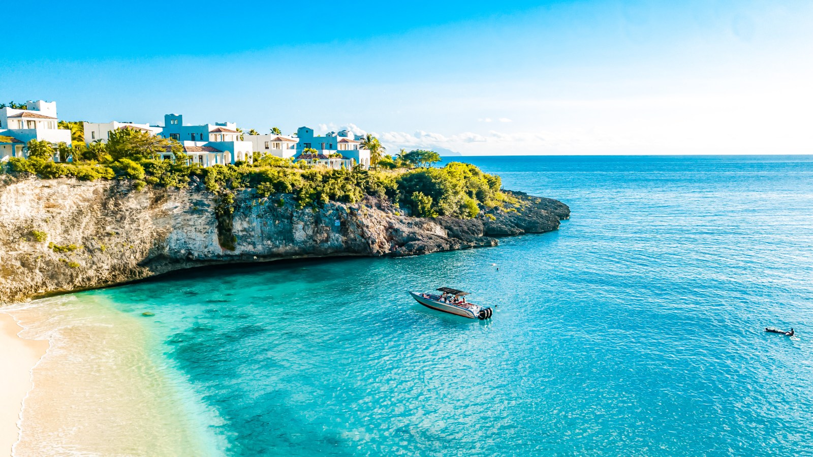 Rocky Saint Martin coastline with a boat at anchor